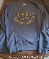 Front view showing Levi logo with yellow text on blue-gray pullover sweatshirt.