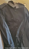 Front view of the navy trench coat showing double-breasted button arrangement and shoulder epaulettes.