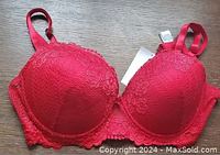 Front view of red lace bra showing padded cups, lace detailing, and adjustable straps.