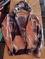 Front view of the zip-up hoodie sweater showing the ribbed honeycomb texture and tie dye pattern in earth tones.