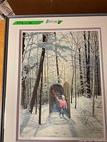 Full view of the framed print leaning against a surface showing the winter forest scene and child