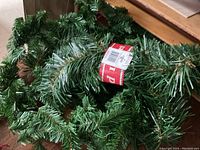 Closeup of artificial pine garland showing green needle details and store label