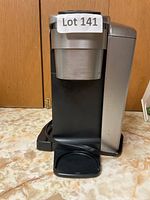 Front view of Keurig coffee maker showing cup holder and body.