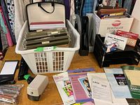 Photo of basket with green ring binders, envelopes, expanding portfolios, file folders, and stacked envelopes