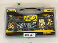 Clear case with compartments showing assorted metal screws, hooks, pins, and brackets with label showing 'Stanley' brand and '684 pcs'.