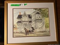 Framed print showing a Victorian-style house with a horse and carriage in front, gold frame and white matting visible.