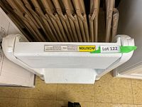 Top view of the folded white plastic step stool showing the textured step surface and caution label.