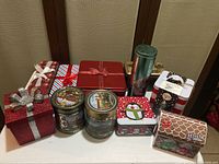 Overhead shot showing all 11 Christmas-themed tin boxes in the lot with various holiday patterns and sizes.