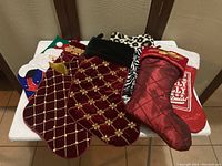 Front view of five assorted Christmas stockings in a variety of colors and patterns laid out on a table.