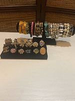 Full view of costume stretch bracelets and decorative rings on black displays.