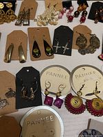 Photo showing assortment of pierced earrings on backing cards including gold tone, silver tone, and colorful beaded designs