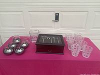 Full lot overview showing 8 frosted cocktail glasses, 4 clear cocktail glasses, wooden bar set box with glass top and drawer, and 5 spherical stainless steel mini ice buckets.