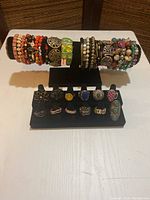 Photo of the full jewelry lot showing colorful stretch bracelets and stretch rings arranged on black display stands.