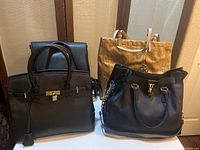 Four Michael Kors bags shown grouped: black leather bags, navy shoulder bag, and gold signature tote