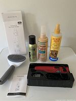 Photo shows the complete dog grooming lot with nail grinder in its box, three spray bottles, and a grooming brush.