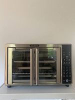 Front view of Gourmia air fryer toaster oven with dual glass doors and stainless steel handles.