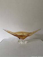 Right side view of mid century modern amber art glass bowl with gondola style arms and clear glass base