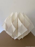 Front view of vintage MCM artichoke chandelier showing translucent white plastic folded petals in geometric pattern on white background.