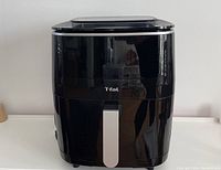 Front view of the black T-Fal Easy Fry Grill & Steam 3-in-1 XXL Air Fryer showing the silver handle and brand name.