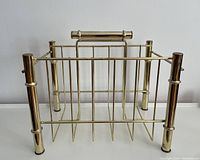Front view of vintage brass magazine rack showing its rectangular shape and handle