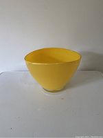 Side view of yellow glass vase/bowl showing curved smooth surface and oval opening.