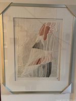 Framed abstract cast paper artwork with textured layered elements and signed by the artist. Front view showing colors, textures, and presentation under glass.