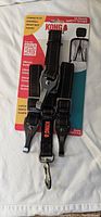 New Kong Travel Ultimate Safety Tether dog seat belt in original packaging with attached adjustable straps and metal clips for secure anchoring.