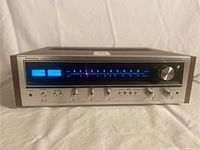 Front view of receiver powered on, showing illuminated VU meters and tuner scale