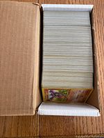 Open box showing stacked Pokémon Fossil cards with one Raichu card visible