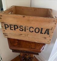 Front view of vintage Pepsi-Cola wooden crate showing solid wood and clear black logo text.