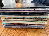 Stack of vinyl albums showing album spines with various titles and colorful designs