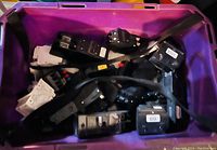 Plastic container filled with multiple electrical circuit breakers of various sizes and amperage ratings.