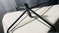 Photo of black metal Christmas tree stand with multiple legs