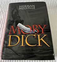 Front cover of the Moby Dick hardcover book showing the dust jacket with prominent title text and whale illustration.