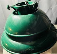 Green plastic Christmas tree stand viewed from above showing central collar and screws to hold tree trunk.