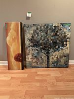 Two canvas prints side by side, a tall narrow floral and a large square tree design