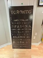 Front view of Toronto typography wall art showing city street names in white distressed text on black background.