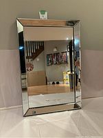 Front view of rectangular beveled edge mirror showing reflective glass and beveled border