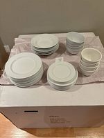 Full set of white dishes arranged on a table, showing all components together including plates and bowls