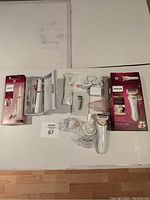 Full lot showing electric shaver, trimmer, charging cable, heads, packaging, and accessories spread on a white surface.