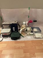 Full view of all picnic supplies on floor including coolers, plates, cups, cutlery, napkins, and beverage pitchers