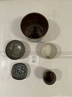 Top view of five pottery pieces showing different shapes and glazes.