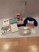 Full collection laid out on soft white surface including journals, yoga book, heating pads, diffuser, candle, slippers, and masks.