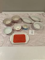 Full lot of assorted ceramic bowls and ramekins on white paper background