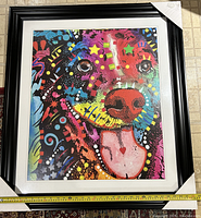 Framed vibrant colorful abstract dog print by Dean Russo showing dog face with tongue out, surrounded by stars and colorful dots.