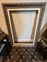 Full view of the large rectangular frame showing the overall size and shape with ornate detailing and linen-style matting