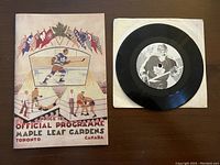 Replica official Maple Leafs programme front cover showing hockey player and flags artwork.