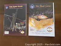 Photo shows two Toronto Maple Leafs hockey game programs side by side on a dark surface. Left program titled 'The First Game' with night image of Air Canada Centre and sculpture. Right program titled 'The Final Game' depicting Maple Leaf Gardens arena at night.