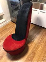 Front and side view of red and black shoe chair, showcasing plush cushioning and shoe-shaped design.