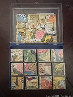 Top view of assembled wooden blocks arranged to create one colorful illustrated scene of a woman in period dress in a kitchen setting with chicken, cat, and other household objects.